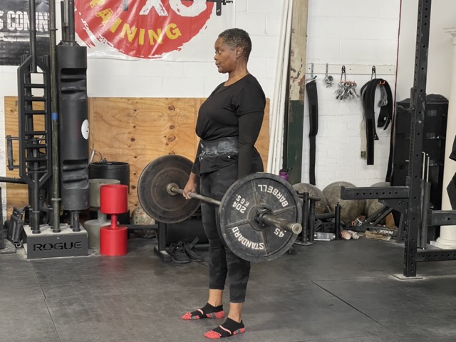 A woman (me) performing a deadlift, showcasing strength, perseverance, and the power of pushing beyond perceived limits.


