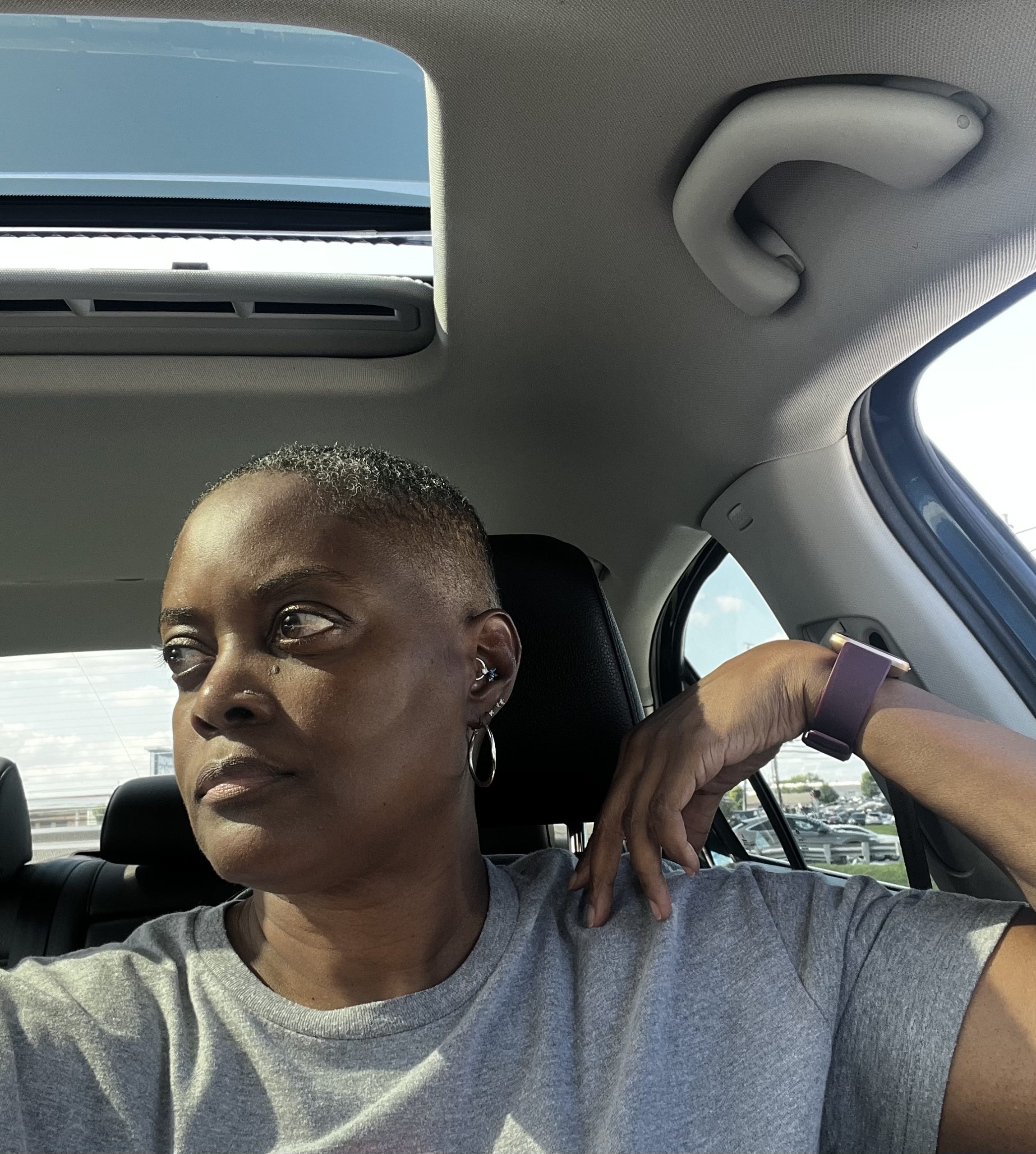 Tami Zanele sitting in her car looking out window, reflecting on life's seasons and God's wisdom.