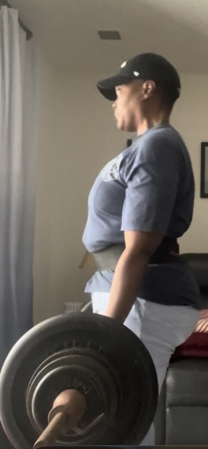 Woman over 50 deadlifting weights in her living room, representing strength training, resilience, and faith-centered wellness.