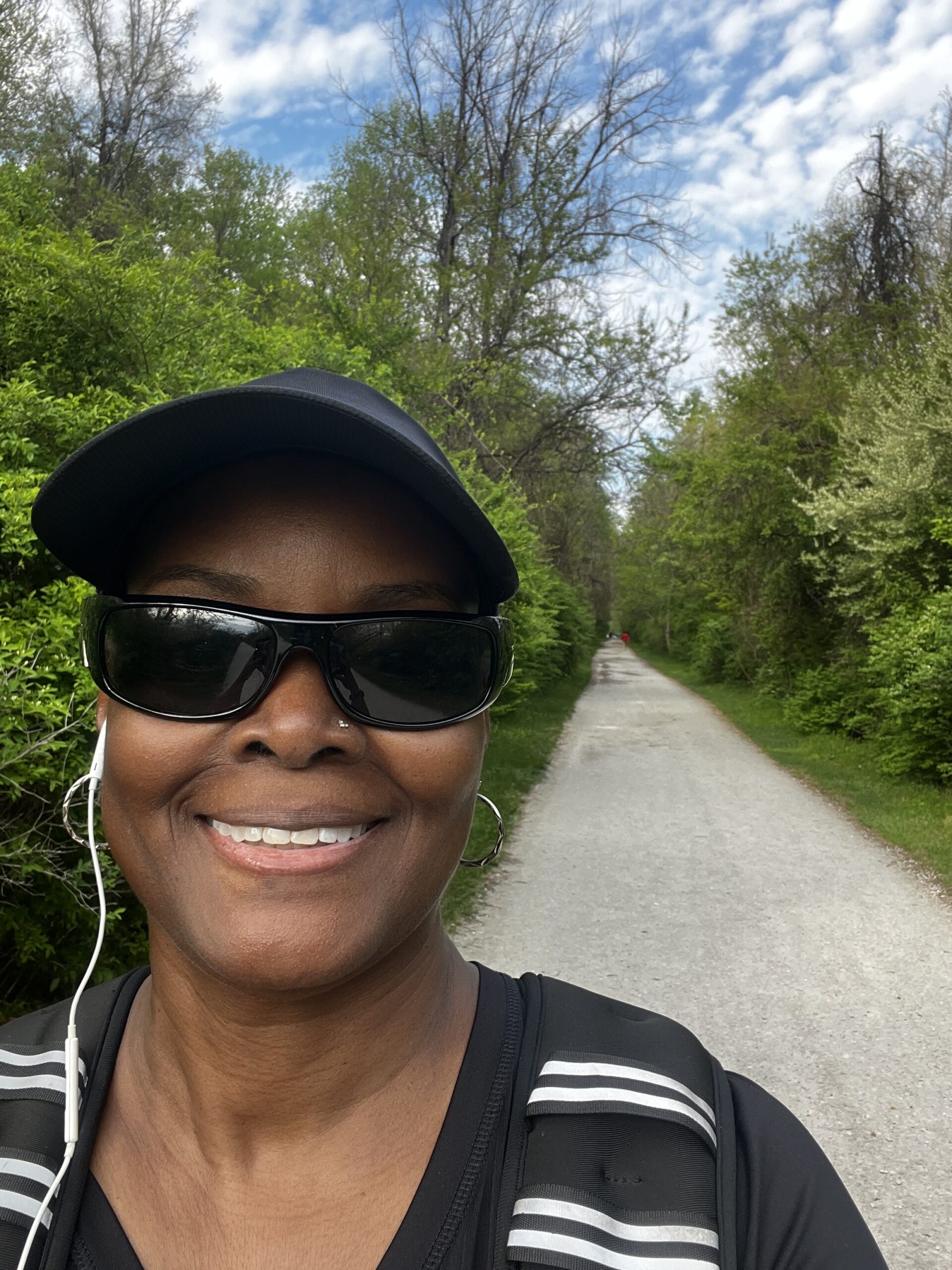 Tami Zanele walking a nature trail, surrounded by trees — returning to the trail for the first time since January as part of her active burnout recovery journey
